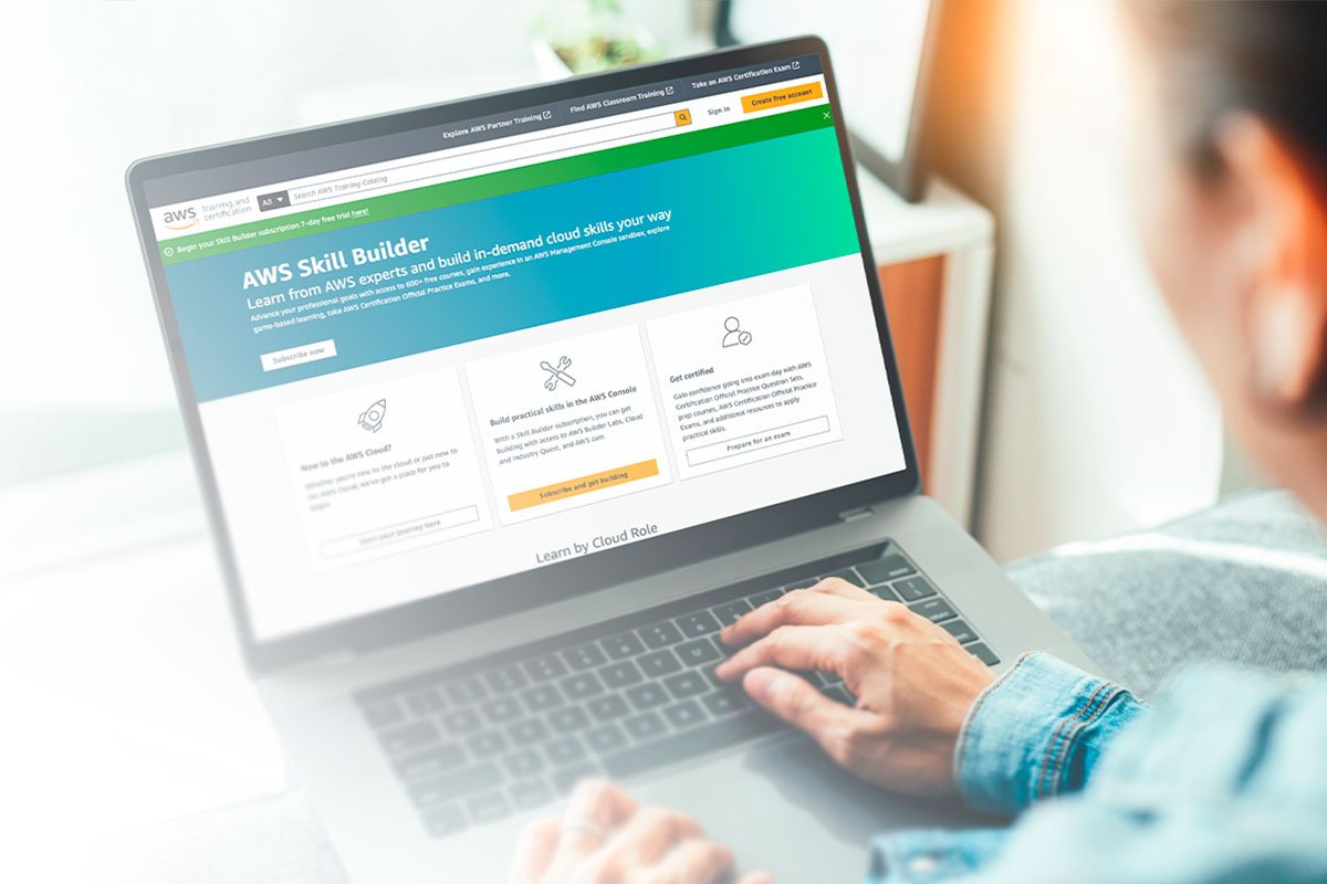 Homem olhando para o notebook com o site da AWS aberto em tela.